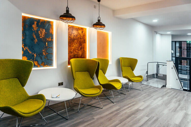 Seating area beside the lift at Coppergate House, with armchairs and a low table