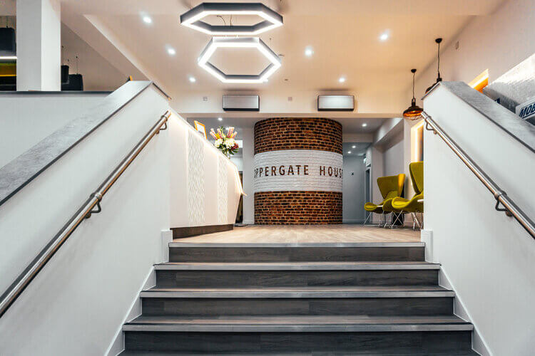 Staffed ground-floor reception at Coppergate House, with brick-clad desk and steps