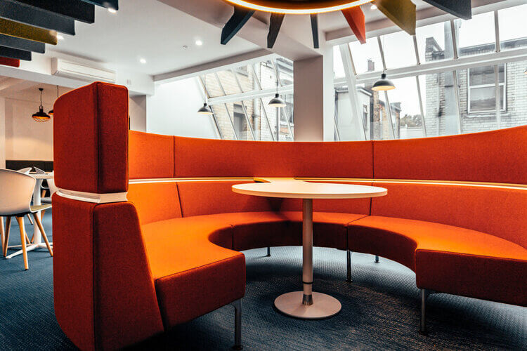 Curved booth seating beneath a glazed roof in the shared area at Coppergate House